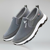 a pair of grey boat shoes for men on a plain background