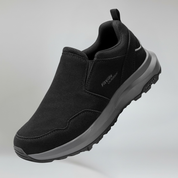Black slip-on shoe with gray sole on a light gray background
