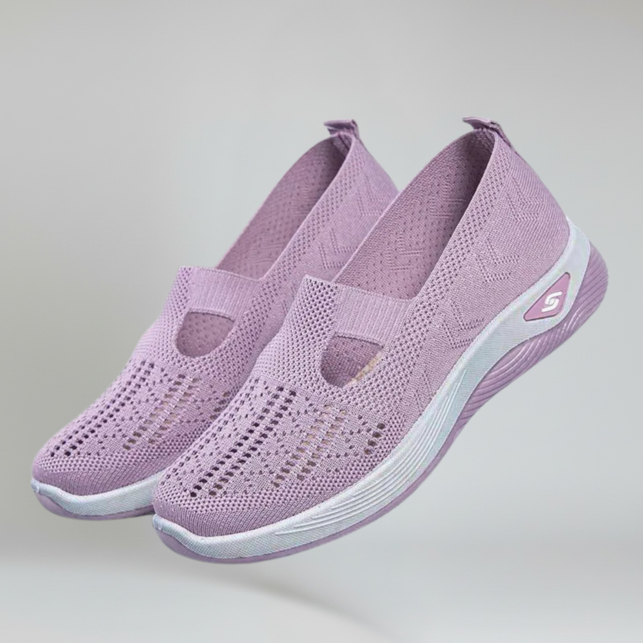 a pair of lavender slip-on sneakers for women on a plain background